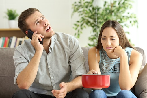 Couple calling insurance for home leaks